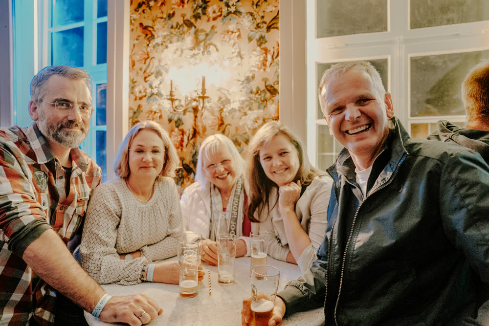 Große Feiergesellschaft stößt gemeinsam an einer langen Tafel an