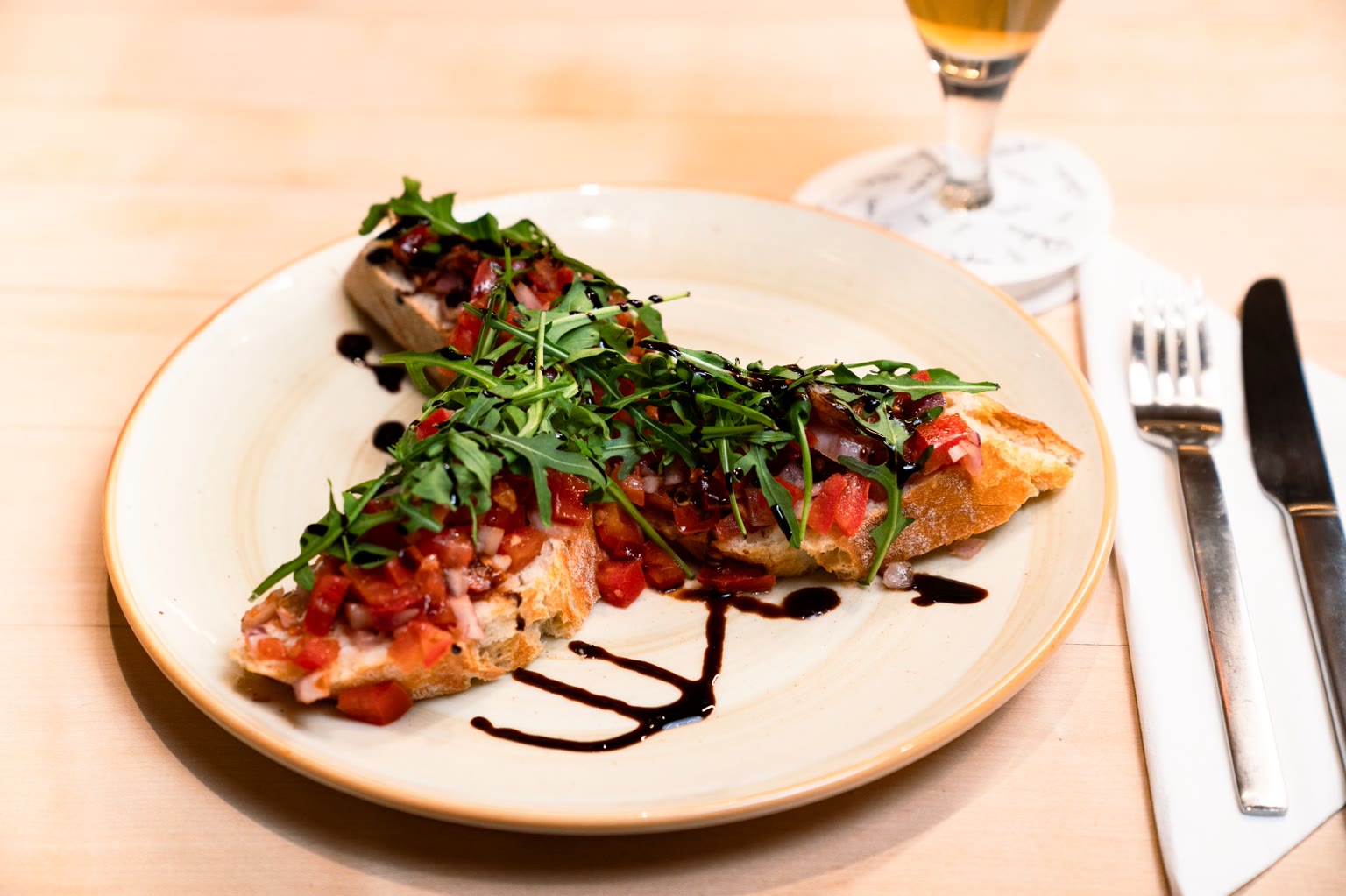 Bruschetta mit Tomaten, Rucola und Balsamico-Reduktion, dazu ein Glas Bier